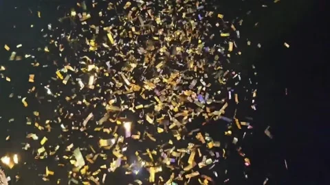 Slow Motion Golden Confetti Falling on Dark Background Stock Footage 317377129
