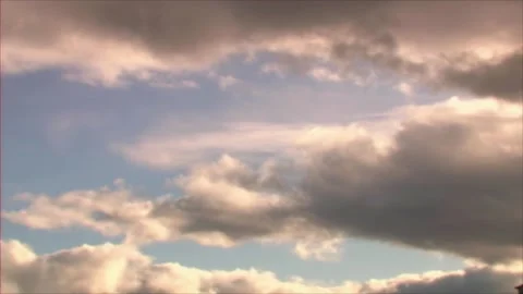 Slow motion of golden fluffy clouds moving softly on the sky and the sun shining Stock Footage 280330470