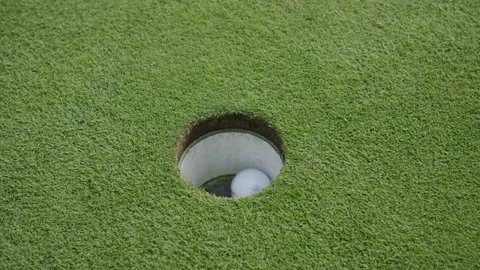 Slow motion golf ball going into hole and being removed 스톡 동영상 153697977