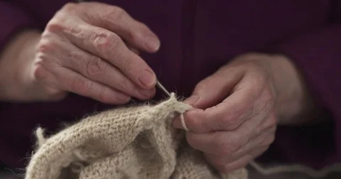 Slow motion of grandmother hands knitting sweater closeup Stock Footage