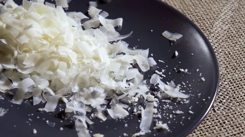 Slow motion. Grating hard cheese. Grated hard cheese flakes fall onto a plate. Stock Footage 295373606