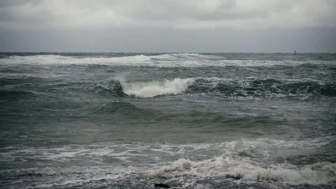 Slow motion gray stormy sea and in the distance a surfer Stock Footage 81961048