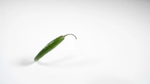 Slow motion green birdseye chilli rolling Stock Footage 88340224