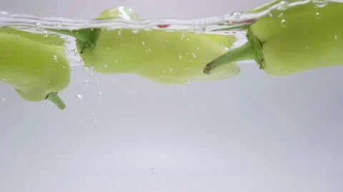Slow Motion Green Chili's Fall Into Water. Healthy Food Background. 스톡 동영상 190229173