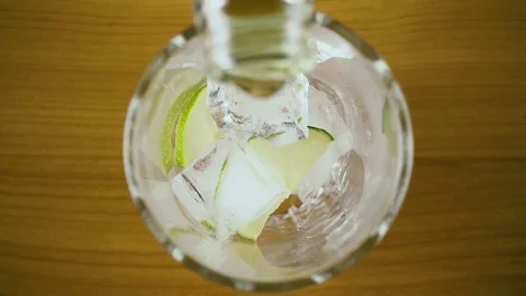 Slow motion. Green drink pour into a glass with ice top view Stock Footage 76766137