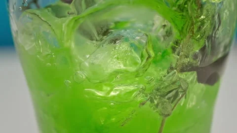 Slow motion green lemonade is poured into a glass with ice close up Stock Footage 148222809
