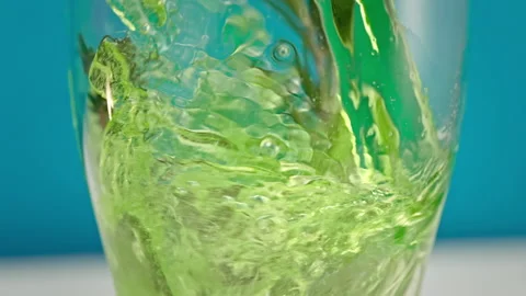 Slow motion green lemonade is poured into a glass with ice close up Stock Footage 148223077