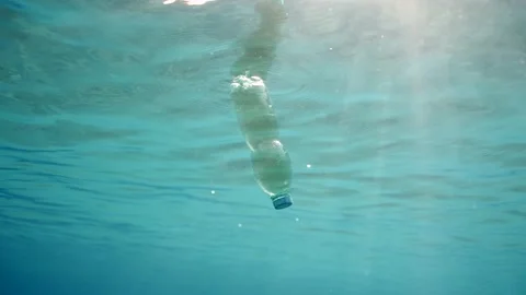 Slow motion, Green plastic bottle drifting under surface of water Stock Footage 233088195