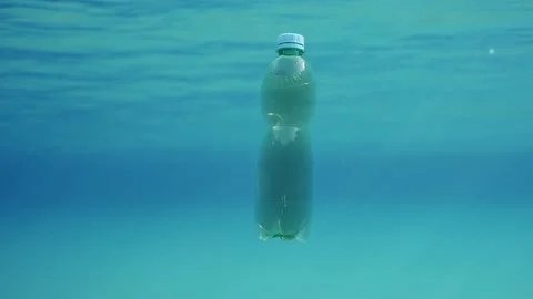 Slow motion, Green plastic bottle swim under surface of blue water Stock Footage 233088331