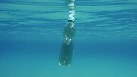 Slow motion, Green plastic bottle drifting under surface of blue water. Stock Footage 233088361