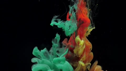 Slow motion green red and yellow ink mixing in water, swirling softly underwater Video stock 164088726
