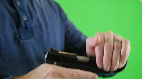 Slow motion green screen shot man loading bullet in pistol chamber Stock Footage 57830827