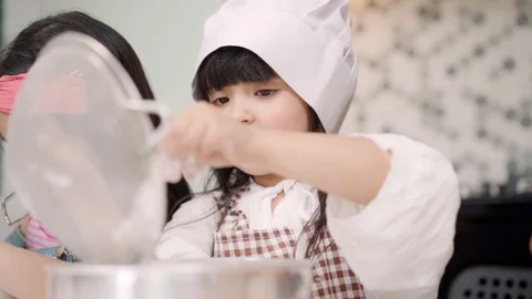 Slow motion - Group of children baking cake together in classroom. Stock Footage 109996211