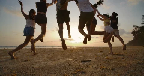 SLOW MOTION - Group of friends running on the beach at sunset with happy emotion Stock Footage 104980323