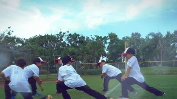 Slow motion of a group of kids stretching legs during baseball practice Stock Footage 85642801