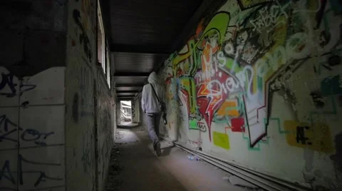 Slow motion of guy with bottle walking through abandoned building Stock Footage 58614676