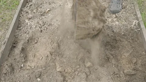Slow motion, a guy digs up soil in a garden bed with a shovel, close-up Stock Footage 315568978