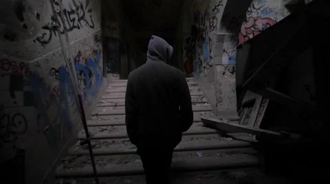 Slow motion of a guy with hood walking through abandoned building Stock Footage 58613644
