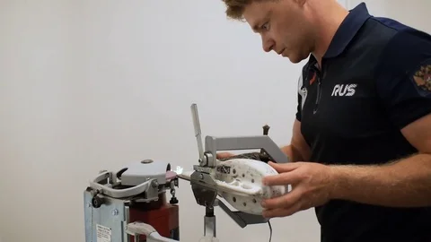 Slow Motion Guy Sharpens Skate with Machine in Sport Complex Video stock 79973932