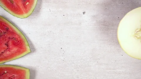 Slow motion half melon rolls on the table on the slices of watermelon top view Stock Footage 93589749