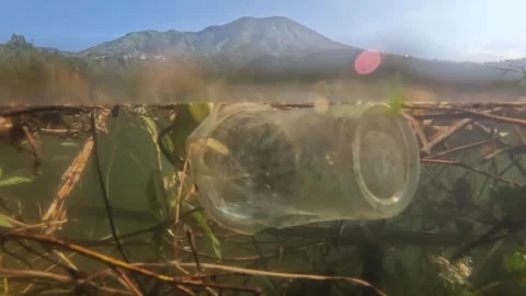 Slow motion half underwater plastic cup trash lake Video stock 319879614