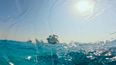 Slow motion half underwater view of rough sea waves and tour boats anchored near Stock Footage 340541291