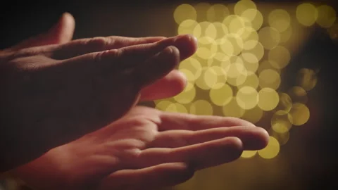 Slow motion hand clapping with golden bokeh background, gentle applause close up Stock Footage 296669075