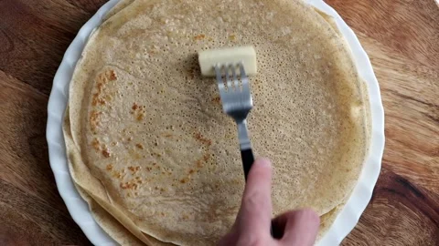Slow motion hand closeup of spreading butter on top of pancakes or blini Stock Footage 230111149
