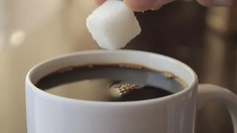 Slow Motion Hand Dropping Sugar Cube Into Black Coffee. Sugar Falling Down Into Stock Footage 266800025