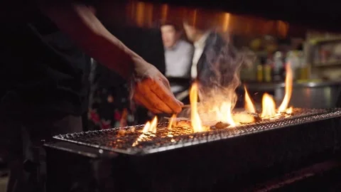 Slow motion of hand flipping grilled food at Fukuoka night street stall Stock Footage 323215466