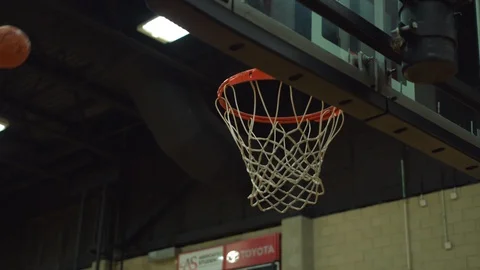 Slow-motion Hand Held Shot of Basketball Going through Hoop Stock Footage 111403995