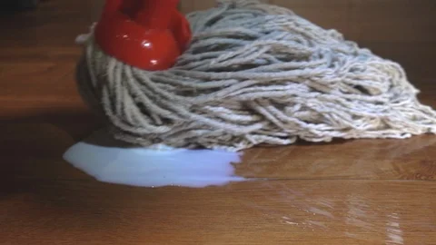Slow motion - Hand lifting plastic carton then mopping up spilt milk on floor. Vídeos de archivo 99778080