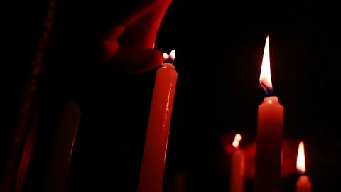 Slow motion of hand lighting red candles in the dark, mirror. Stock Footage 170389193