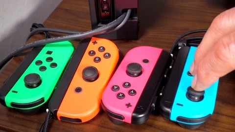 Slow motion – Hand lining up four console game controllers. Video stock 107465607