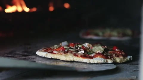 Slow-motion of a hand made pizza in a traditional wood fire oven Stock Footage 248357164
