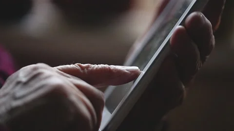 SLOW MOTION: The hand of old human and electronic tablet. Close up Stock Footage 43665814