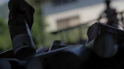 Slow motion of a hand picking color spray cans in the backlight Stock Footage 51734422