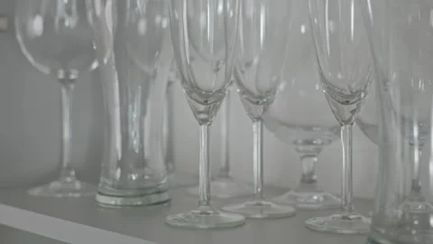 Slow motion of hand picking wine glasses from shelf Stock Footage 313683098