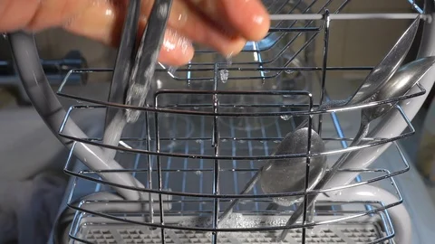 Slow motion – Hand placing soapy spoons into a sink drainer. Stock Footage 119767403