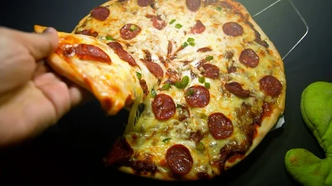 Slow motion of hand pull the cheesy pizza. zoom in footage Stock Footage 103276452
