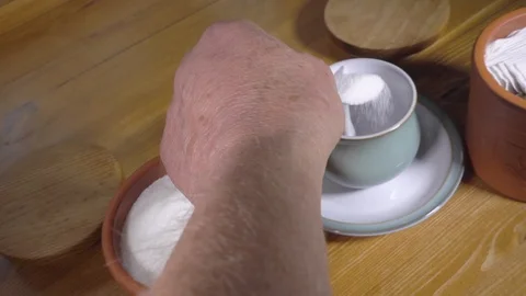 Slow motion – Hand putting a spoonful of sugar into a teacup. Video stock 119659585