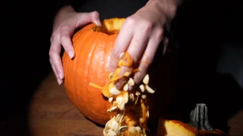 Slow motion hand scooping out pumpkin seeds Stock Footage 141547335