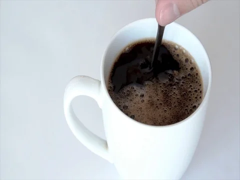 Slow motion hand stirring sugar in white coffee cup Stock Footage 76509026