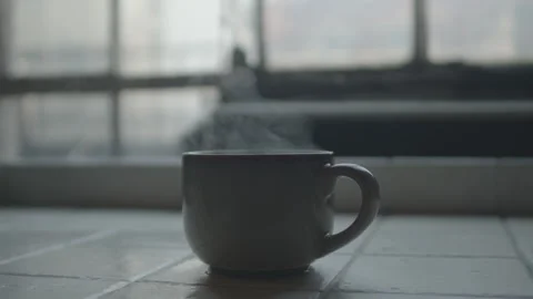 Slow Motion Hand Taking Steaming Cup of Tea by Window Light Stock-Footage 320063097