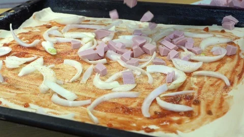 Slow motion hand throws the sausage on raw pizza dough on the onion and sauce Stock-Footage 127086576