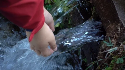 SLOW MOTION  : Hand touch  crystal clear water in mountain spring. Stock-Footage 97117017