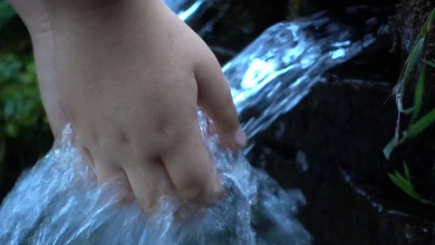 SLOW MOTION  : Hand touch  crystal clear water in mountain spring. Stock Footage 97117166
