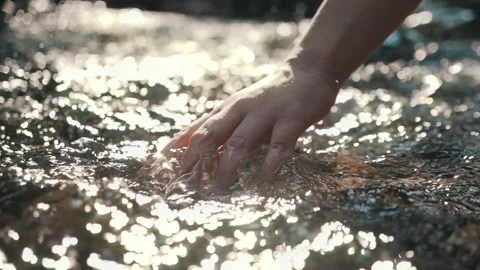 Slow motion of hand touching water in the forest river Stock Footage