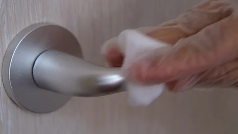 Slow motion: A hand wearing rubber glove cleans door handle by alcohol slice Video stock 126902625