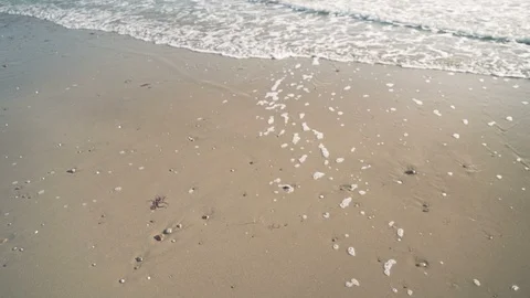 Slow motion handheld shot of gentle waves lapping pristine sand v2 Stock Footage 119533725